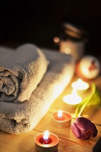 Towels and lit candles linking stress reduction using massage