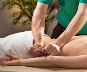 therapist giving relaxing massage to a guy