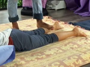 Using feet to massage someones legs during thai massage treatment